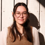 A Malaysian Chinese English woman with long dark hair and glasses.