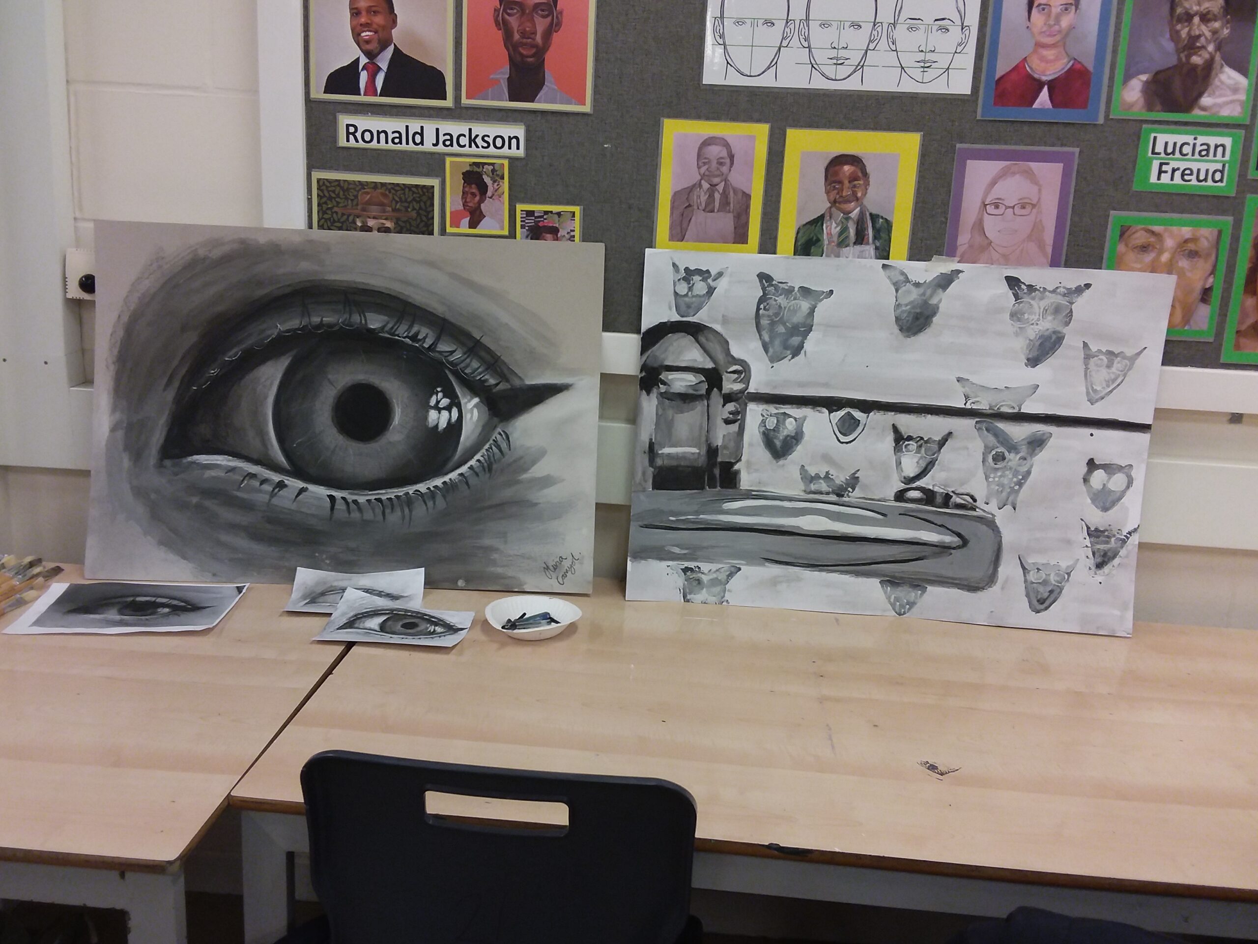 Two students' work sit propped up on a table