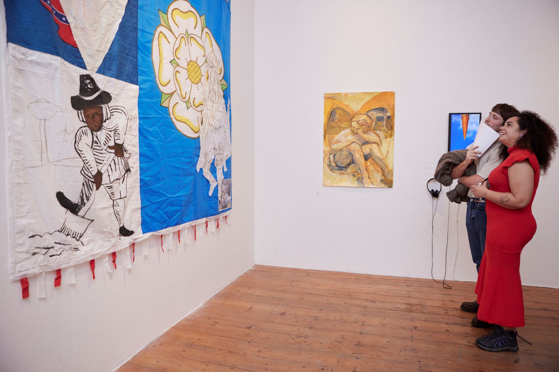 Two people look up at a banner in a gallery