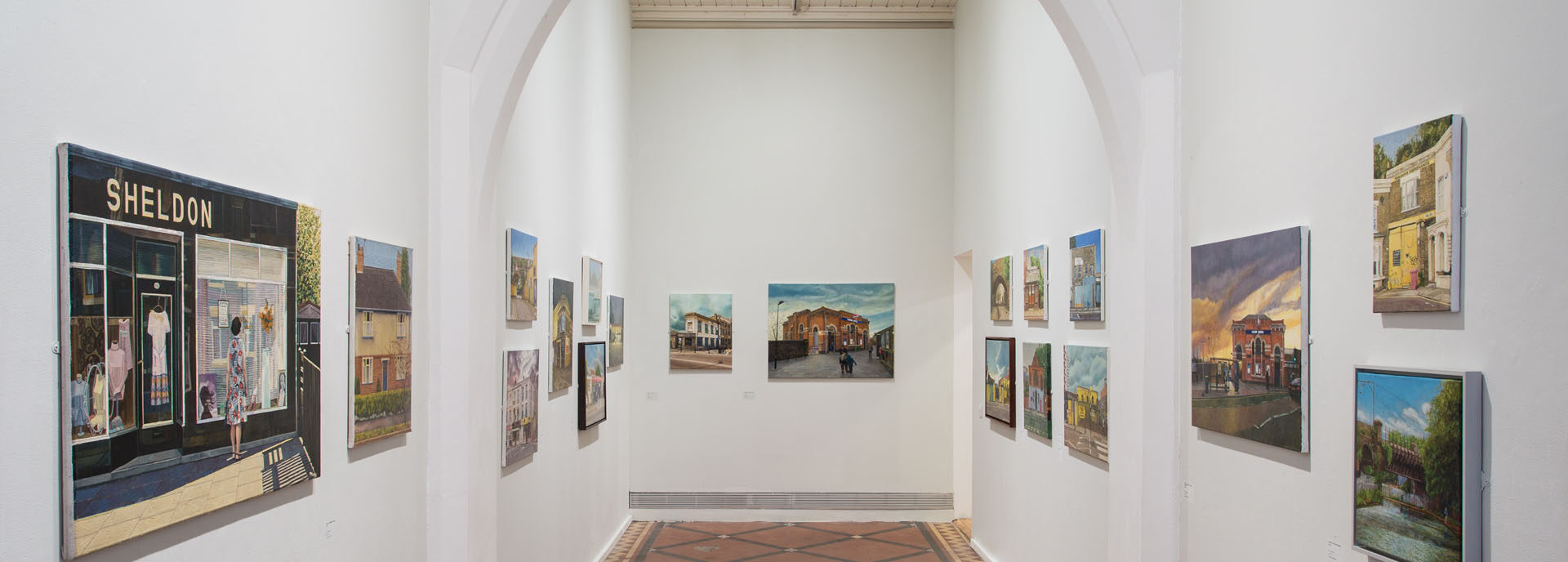 The nave space of the Nunnery Gallery featuring paintings by Doreen Fletcher of east London streets and buildings