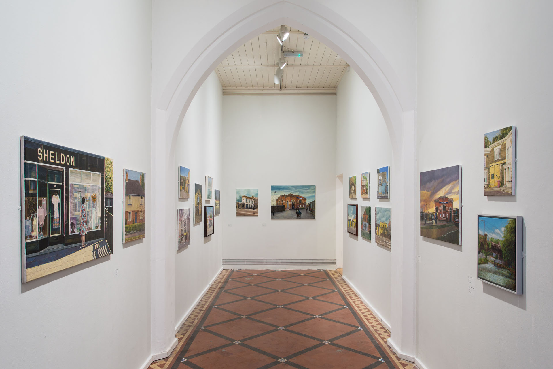 The nave space of the Nunnery Gallery featuring paintings by Doreen Fletcher of east London streets and buildings