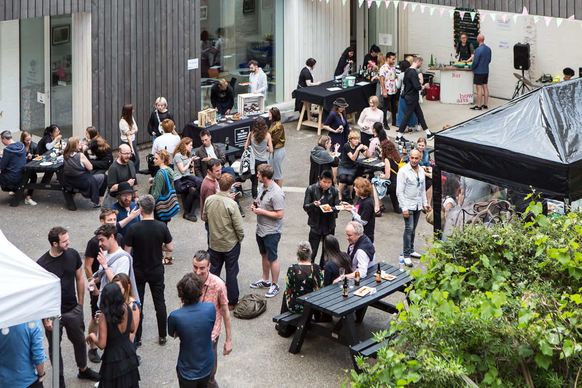 People mingle in the Bow Arts courtyard, eating and drinking