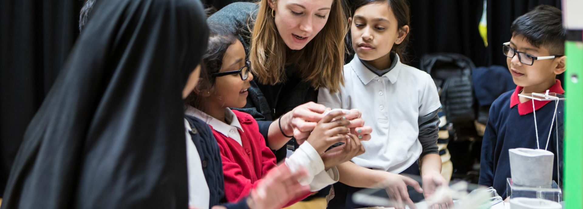 Pupils play with clay, helped by an artist educator.