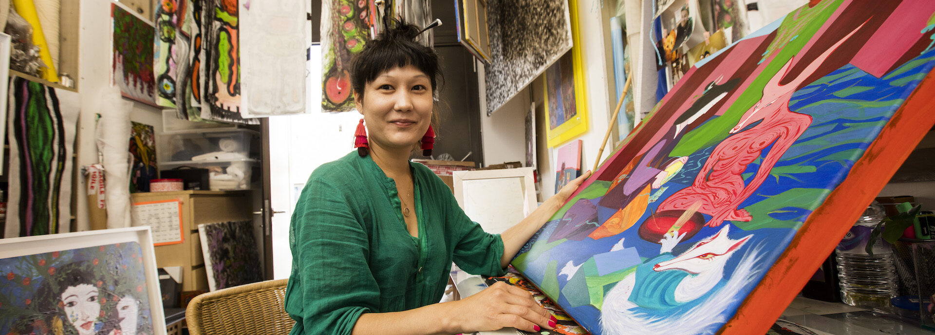 Artist with painting in studio