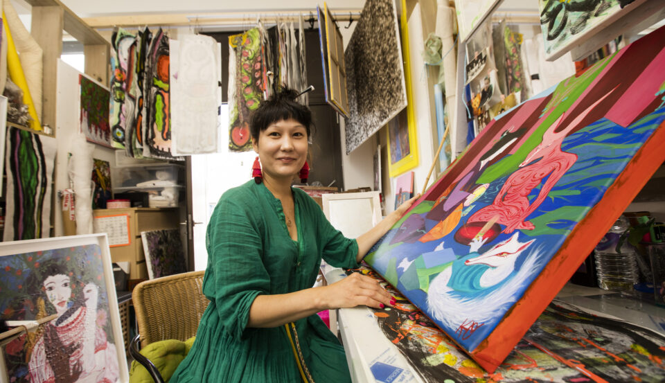 Artist with painting in studio