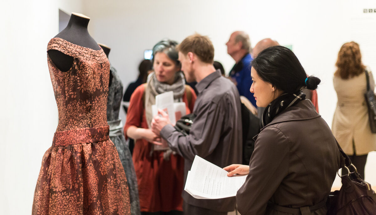 A person looks at a dress on a mannequin