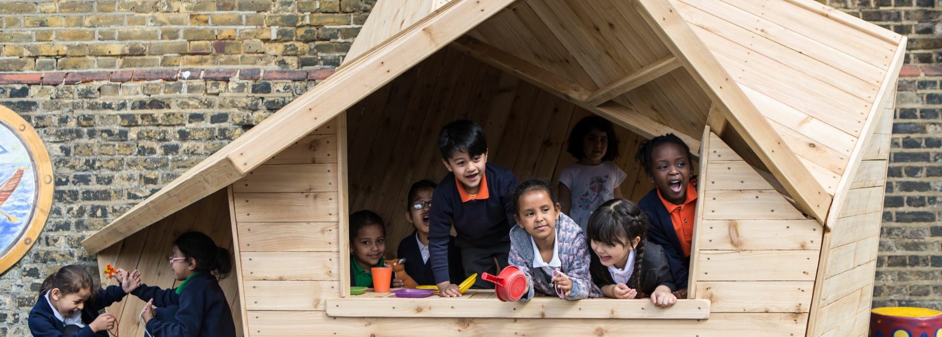 Pupils play in a wooden structure, that resembles a house