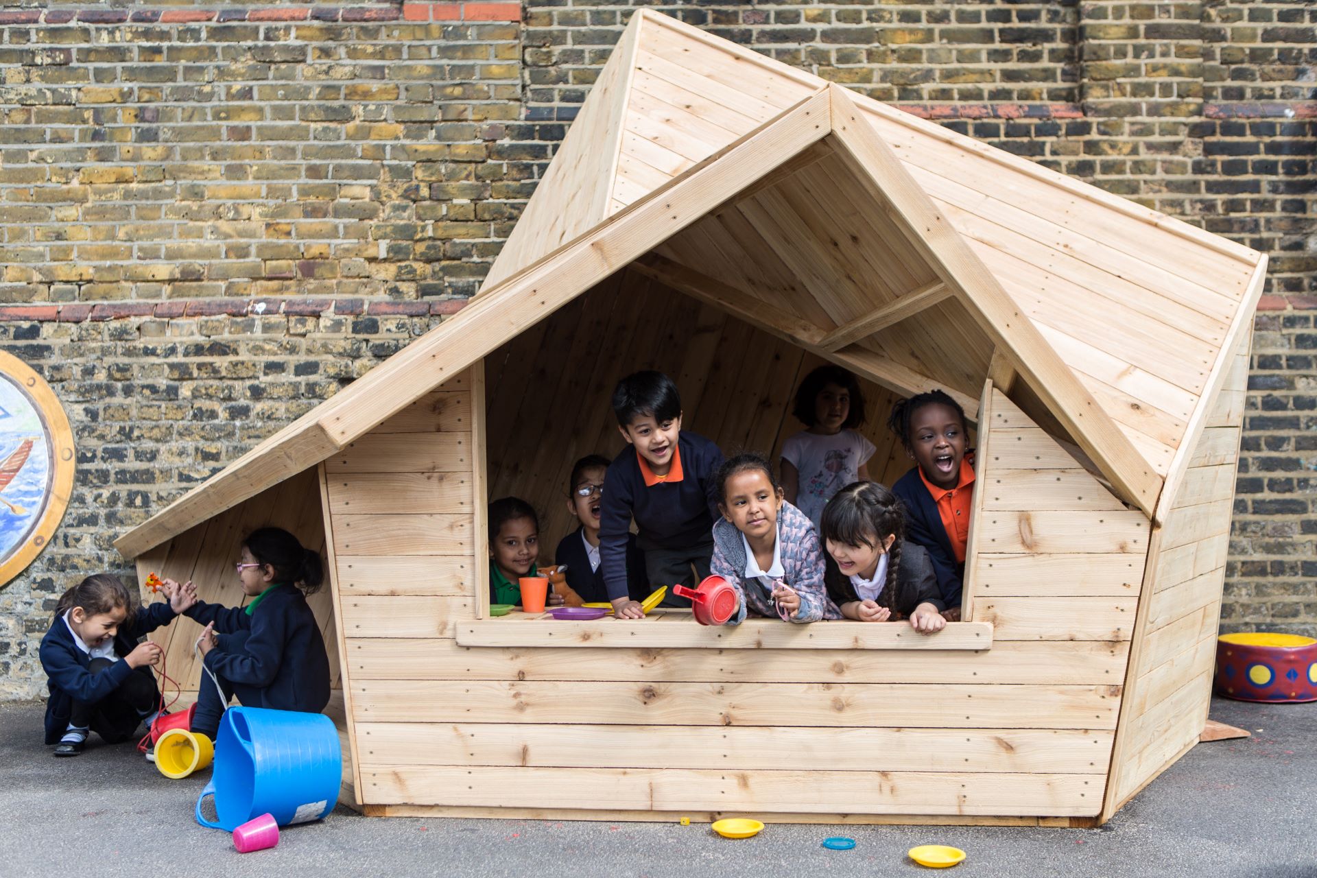 Pupils play in a wooden structure, that resembles a house