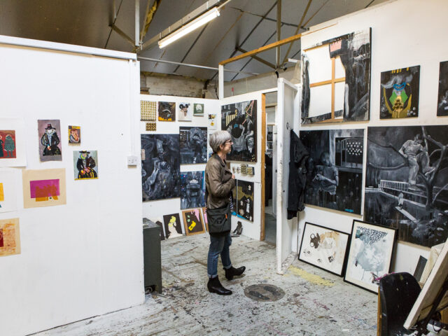 A person looks at artwork on the wall of a studio