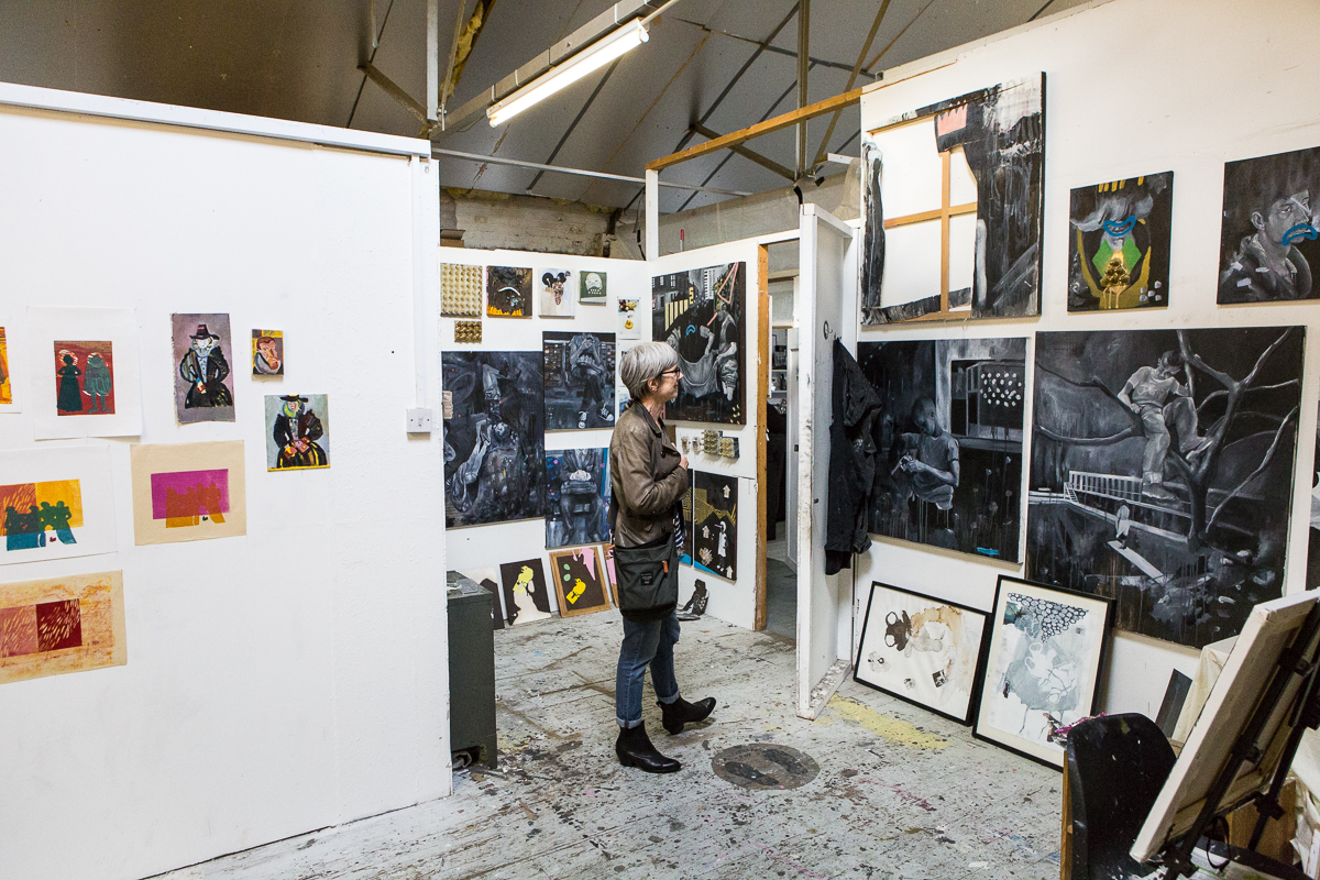 A person looks at artwork on the wall of a studio