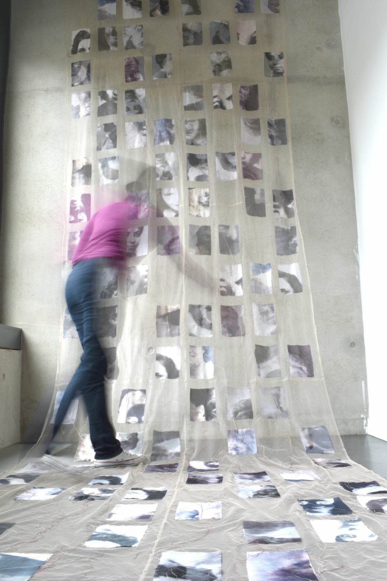 A blurred artist works on a photography installation