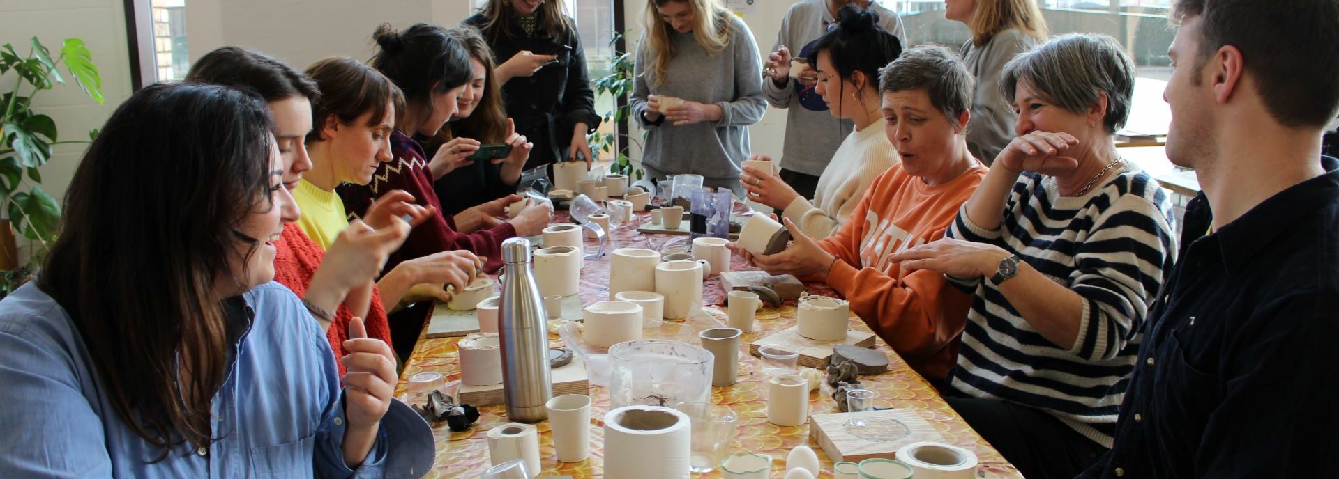 Teacher sit round a table working with clay