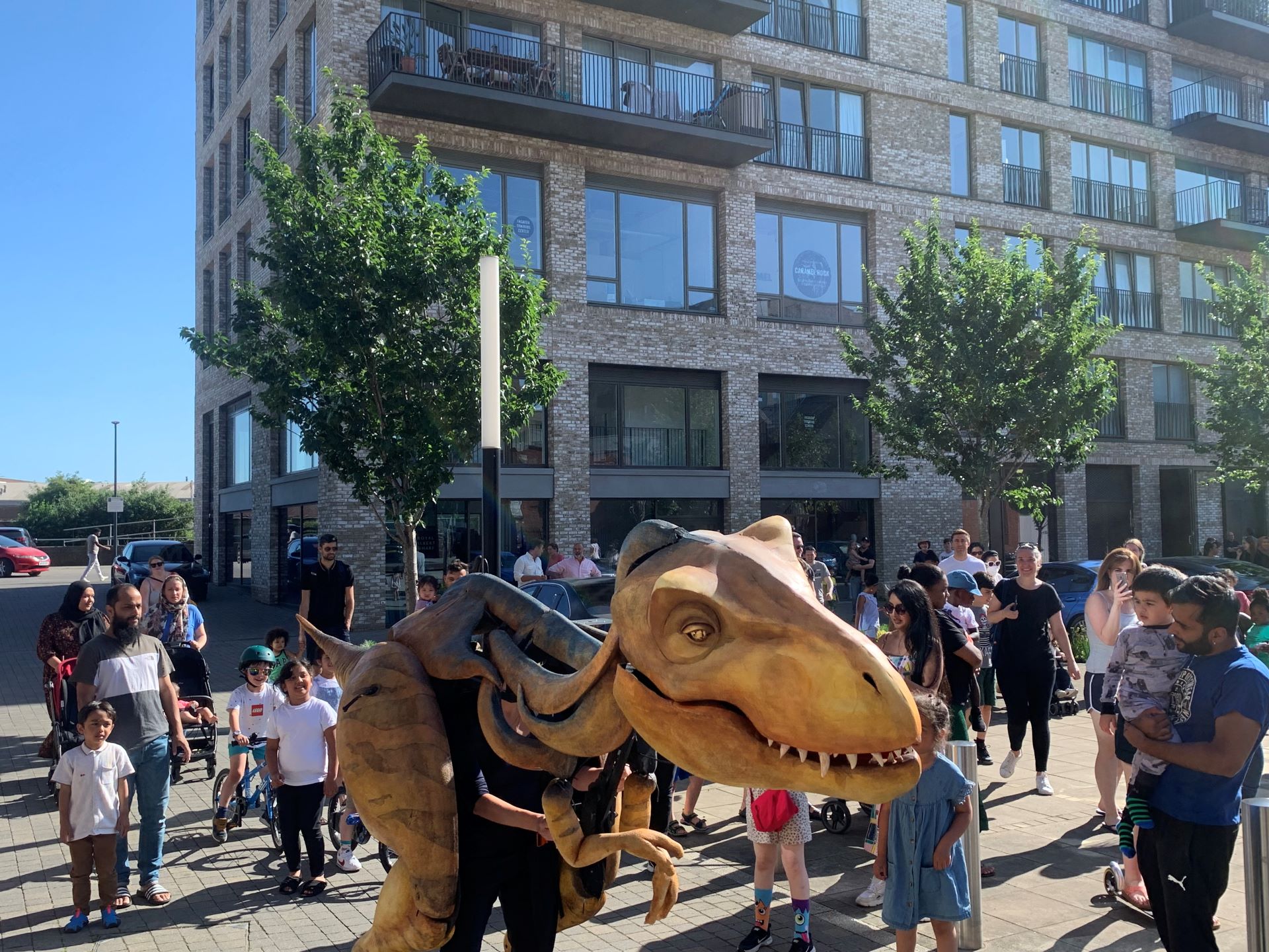 Families follow Charlie Tymms Dinosaur at Royal Albert Wharf