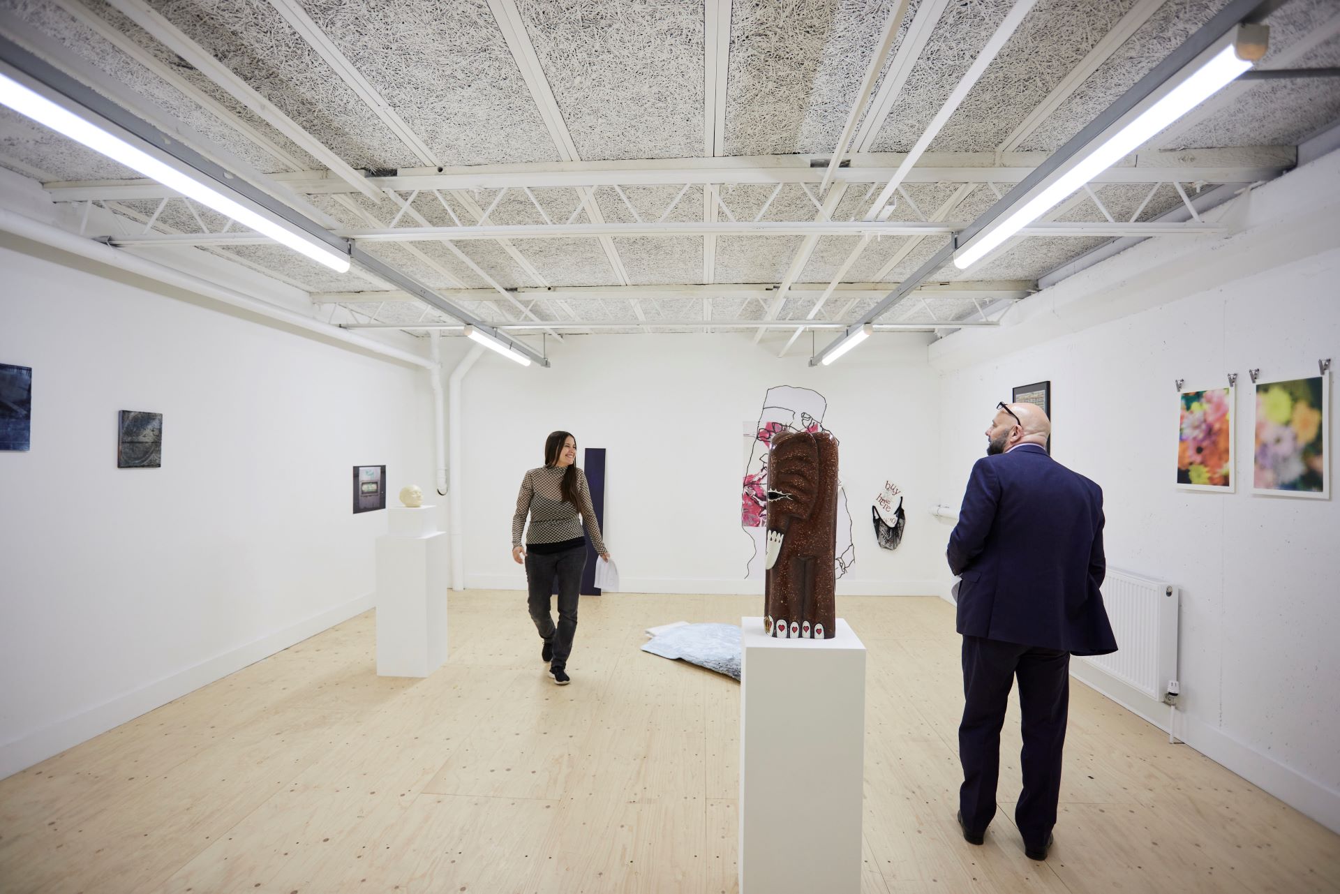 The Media Space at the Lakeside Centre with two people enjoying the artwork on displat