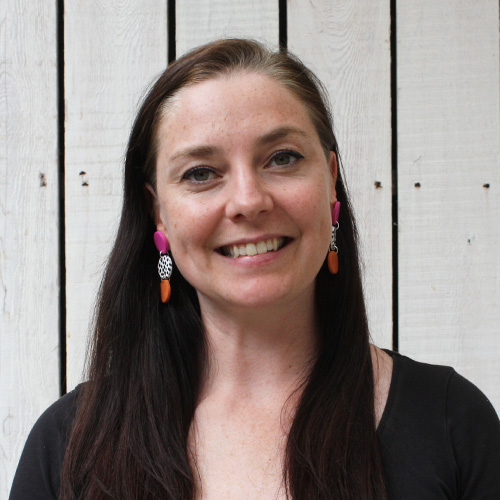 Michelle McGrath shoulders and head, in front of wooden panels