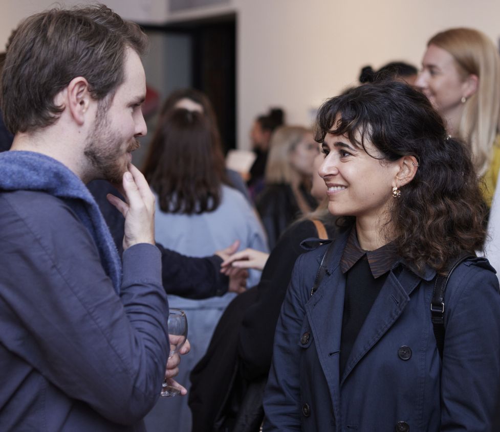 Two people converse in a crowded Nunnery Gallery