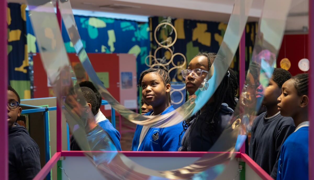 Children look at their artwork on display