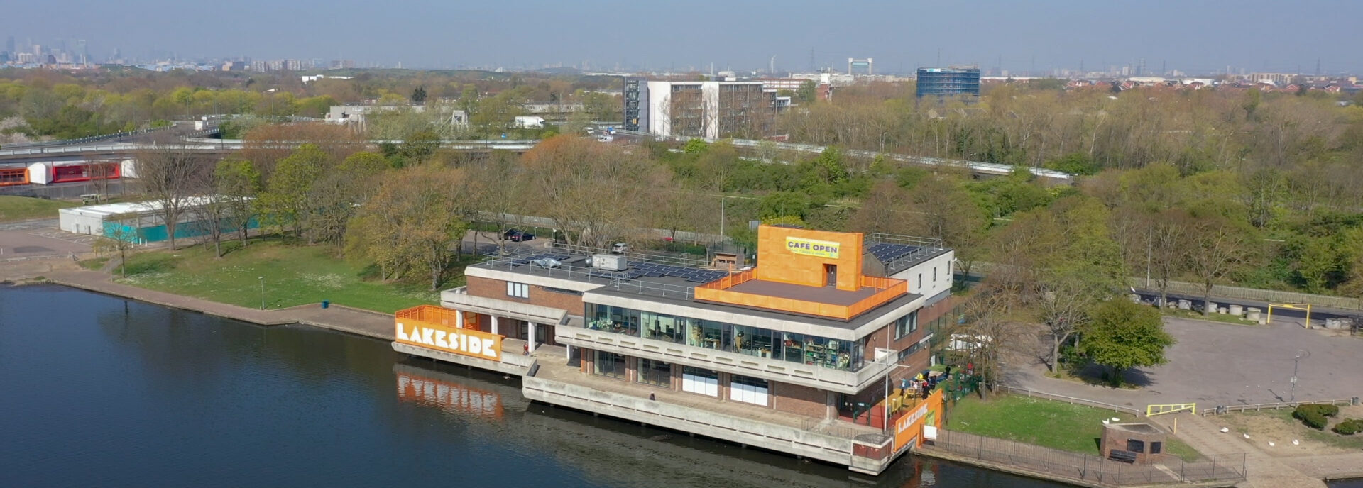 A view of The Lakeside Centre, a 1960s Brutalist building on Southmere Lake. The building's solar panels are visible.