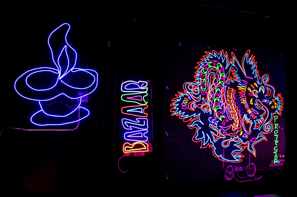 three neon light installations a lamp, the word /bazaar' and a dragon