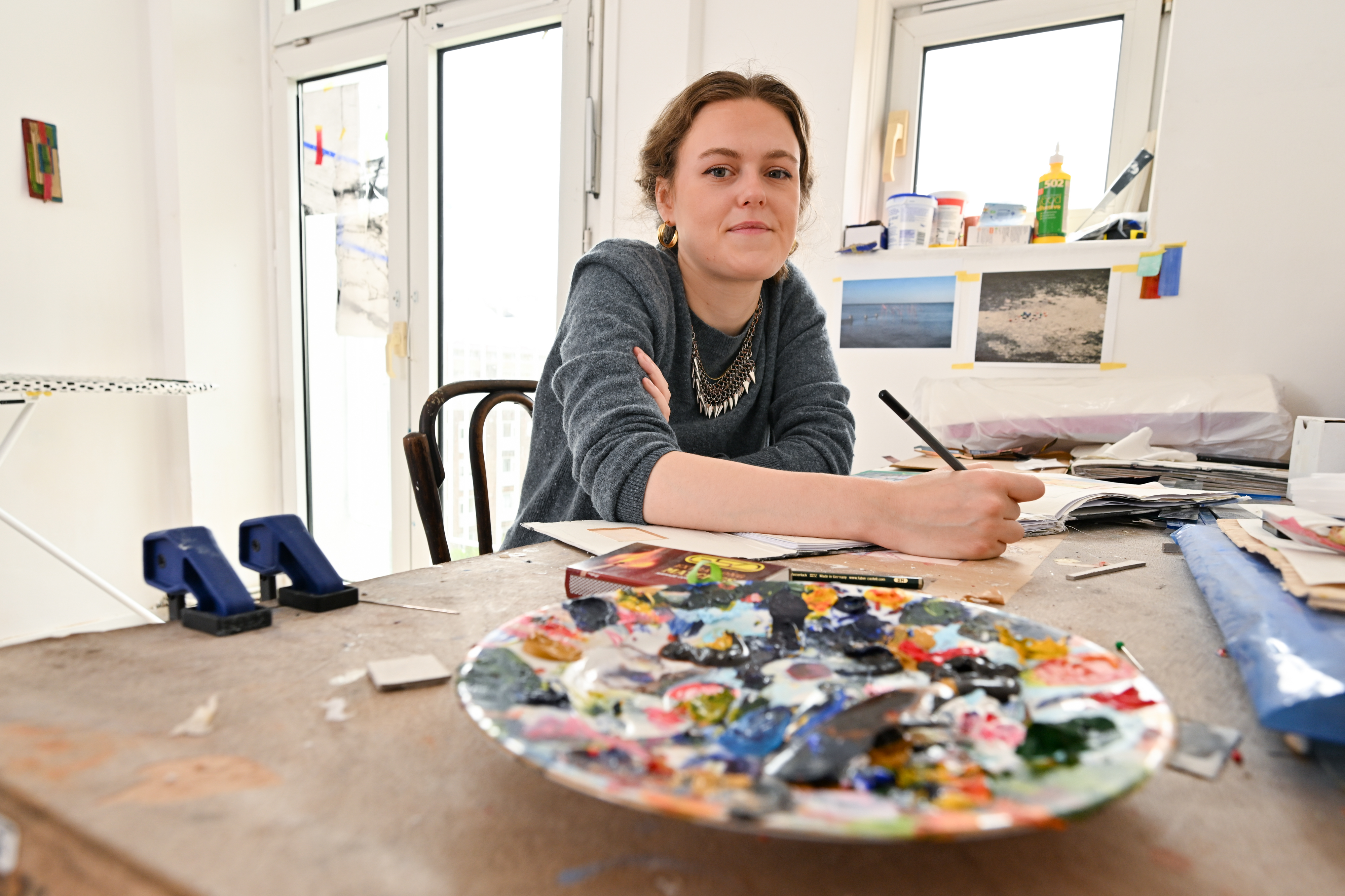Artist Eliza Owen with a  paint palette in her studio in Camden