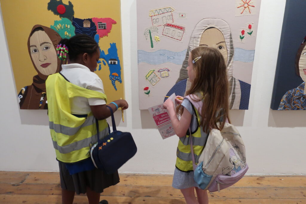 Two students work on the Nunnery Family Trail in front of Lucy Orta's Portrait Gallery