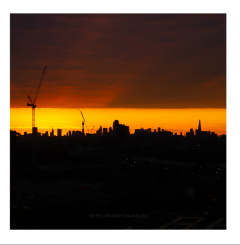 a skyline at sunrise with a band of bright orange horizon.