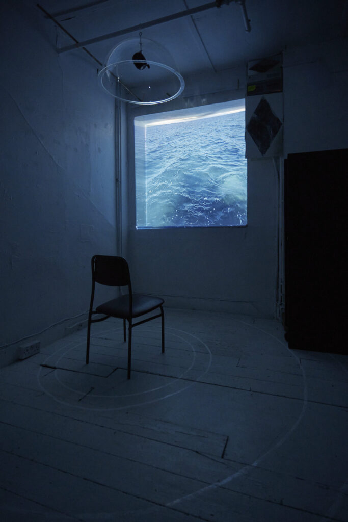 a chair sits in a circle in front of a blue screen