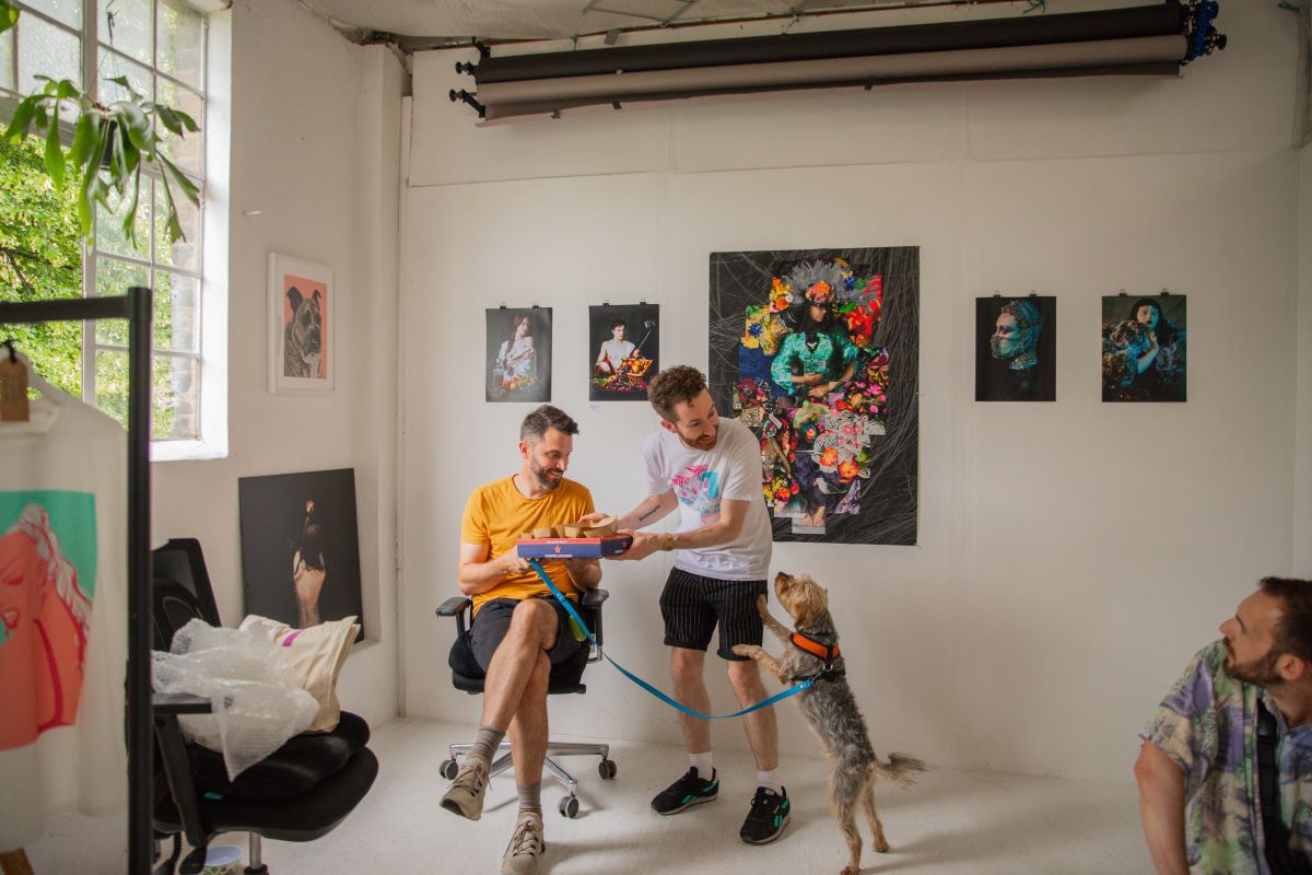 two artists in their studio with a dog